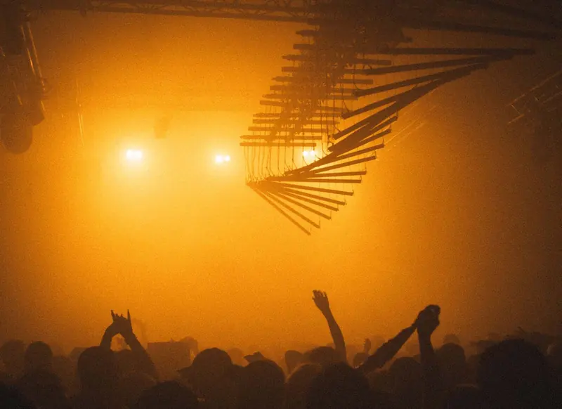 Crowd under orange lights. Photo by Iheb Fehri