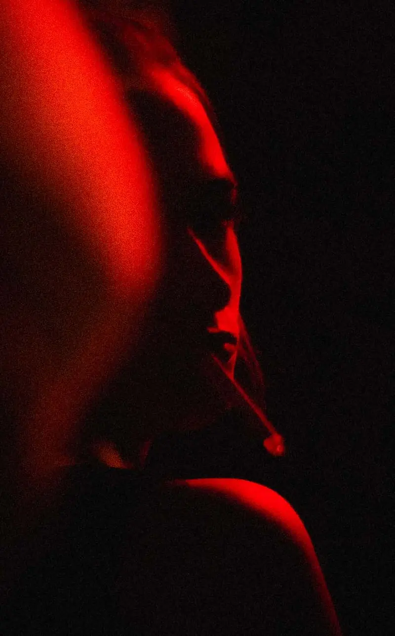 Smoking profile in red light. Photo by Iheb Fehri