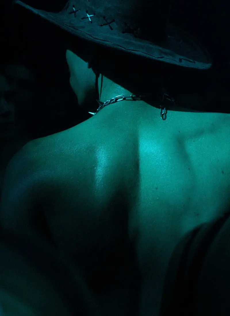 Bare back and hat in teal light, Spectrumwaves, La Station Gare des Mines, 2026. Photo by Iheb Fehri