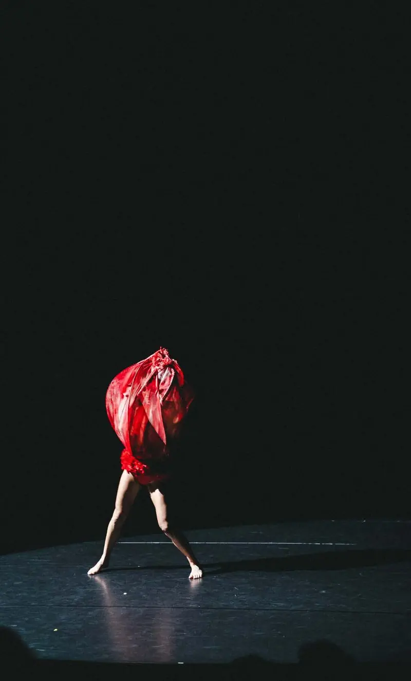Dancer hidden under red fabric, Quand je souris... - Sarah Adjou, Les Plateaux Sauvages, Paris, 2026. Photo by Iheb Fehri