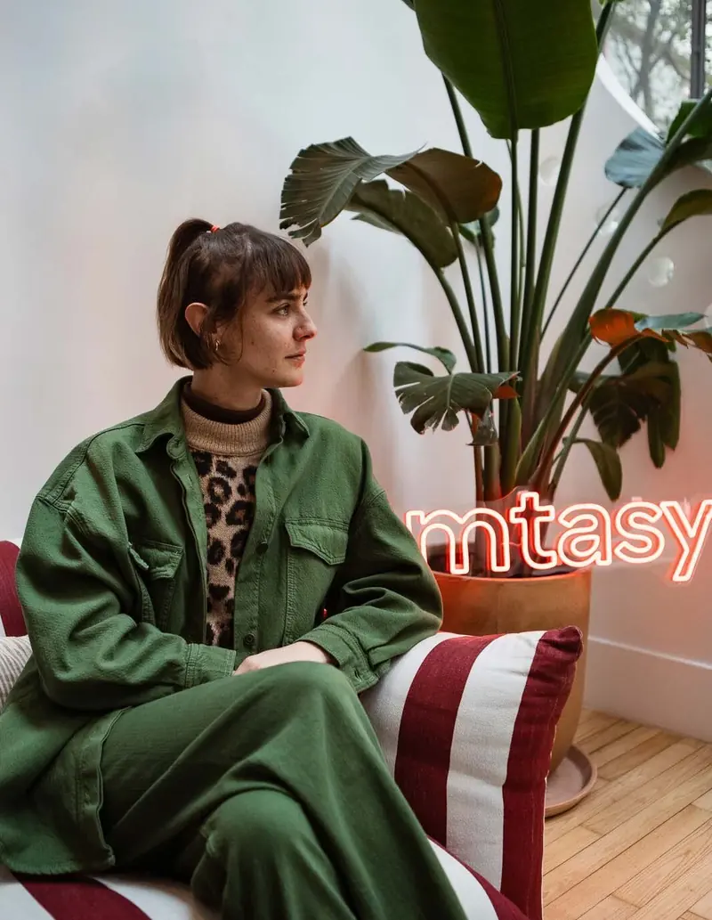 Woman seated by a neon sign, Influencer event documentary - Femtasy, Paris, 2024-2025. Photo by Iheb Fehri